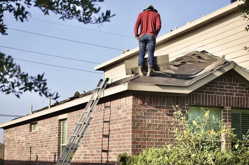 Professional roofer working on a residential roof in Winderly